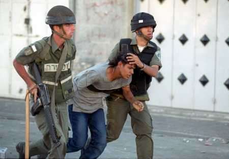 Israeli soldiers arresting a Palestinian boy