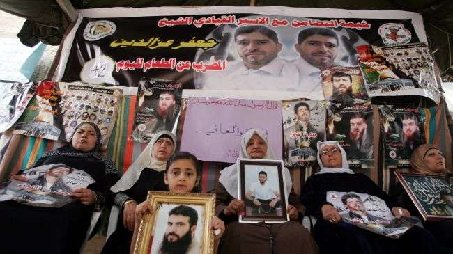 Palestinian demonstrators in northern West Bank hold pictures of relatives held in Israeli prisons, May 2, 2012.