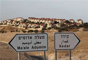 The illegal settlement of Maale Adumim, near Jerusalem, is seen behind sign posts, Dec. 3.