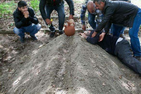 People mourn at the grave of a dead miner after the burial service in a cemetery in Soma, a district in Turkey western province of Manisa May 14, 2014.