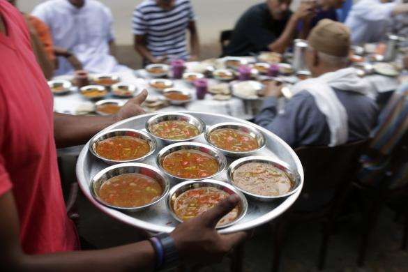 A volunteer serves iftar the breaking of fast meal for free at charity tables on a street during the first day of the holy month of Ramadan in Cairo June 29 2014.