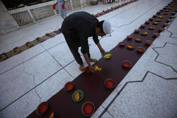 A boy arranges the food before breaking fast on the first day of Ramadan the holiest month in the Islamic calendar at a mosque in Peshawar June 29 2014.