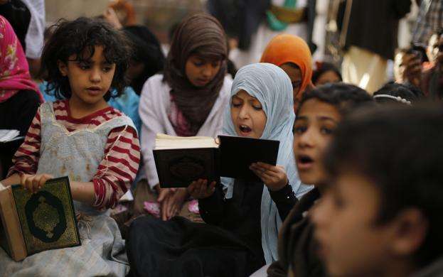 A girl recites the Quran during the Muslim fasting month of Ramadan at the Grand Mosque in Sanaa June 29 2014.