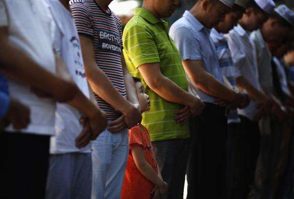 A boy attends a Friday prayer outside a worship hall of the Niujie Mosque in Beijing June 27 2014.
