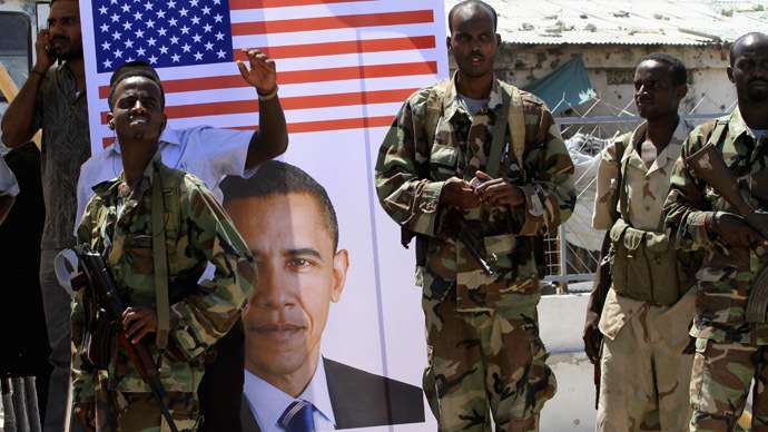 Somali soldiers stand next to a poster of U.S President Barack Obama during a rally welcoming the announcement that the United States has officially recognized Somalia