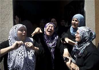 Palestinian women mourn during the funeral of Hafez Hammad, a senior Islamic Jihad commander, and five of his relatives, who were killed when an Israeli missile slammed into their house in the northern Gaza Strip town of Beit Hanoun, on July 9, 2014