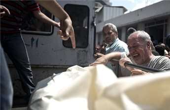 A Palestinian man from Halaq family grieves over the body of a relative outside the morgue of the al-Shifa hospital, in Gaza City, on July 21, 2014