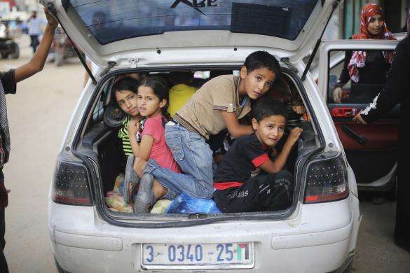 Palestinian children sit in a car boot as they flee their family homes following heavy Israeli shelling during an Israeli ground offensive east of Khan Younis in the southern Gaza Strip July 23 2014.