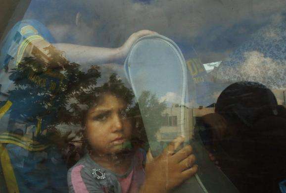 A Palestinian girl sits in a minibus after fleeing her family house during heavy Israeli shelling in Gaza City July 20 2014.
