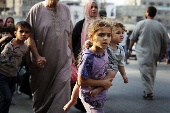 Palestinians flee the Shujayeh neighbourhood during heavy Israeli shelling in Gaza City July 20 2014.