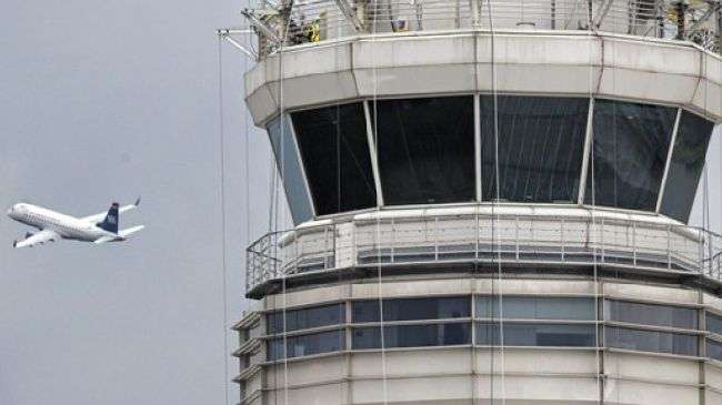 In this March 24, 2011 file photo, a passenger jet flies past the FAA control tower at Washington