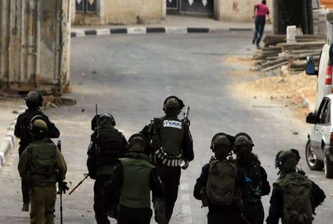 Israeli soldiers chase a Palestinian in the West Bank city of al-Bireh.