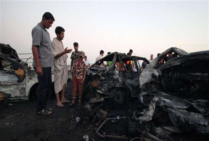 Iraqis look at the damage following a car bombing at a vehicle market in Baghdad’s northern district of Sadr City, August 15, 2015.