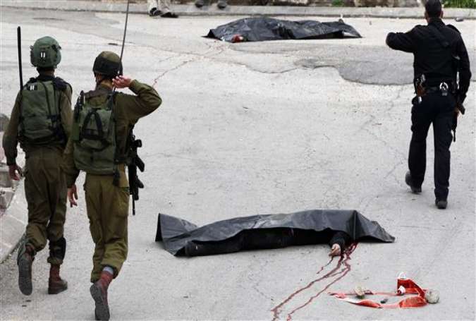 Israeli forces surround the bodies of two Palestinians who were killed in the West Bank city of al-Khalil (Hebron) on March 24, 2016.