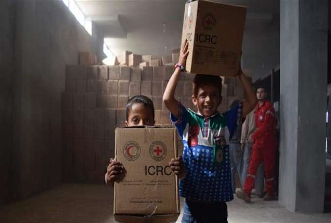 Syrian children carry aid parcels after a convoy of the International Committee of the Red Cross (ICRC) and the Syrian Arab Red Crescent entered the terrorist-held town of Talbiseh, north of Homs, May 2, 2016.