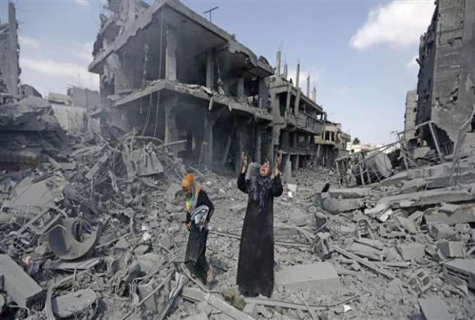 A Palestinian woman pauses amid destroyed buildings in the northern district of Beit Hanoun in the Gaza Strip on July 26, 2014.