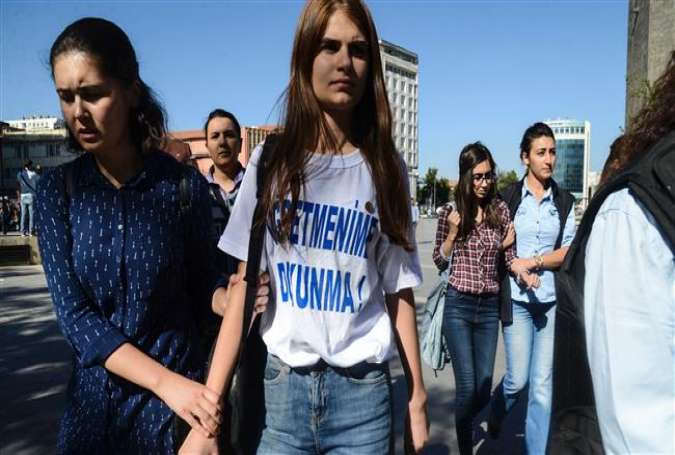 Turkish police detain a student wearing a t-shirt reading "Don