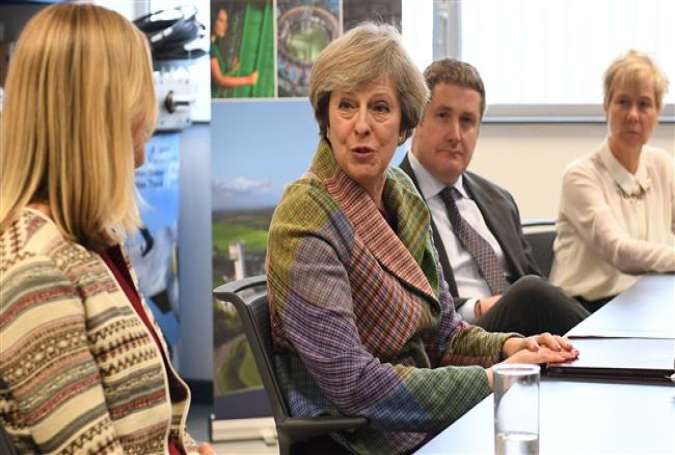 British Prime Minister Theresa May (C) meets local business leaders at Ski-Tech Daresbury in Warrington, north west England on January 23, 2017.