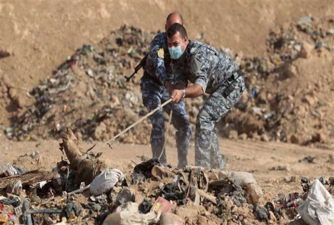The photo shows members of the Iraqi police inspecting a mass grave of Daesh victims near Mosul on November 7, 2016. (Photo by AFP)