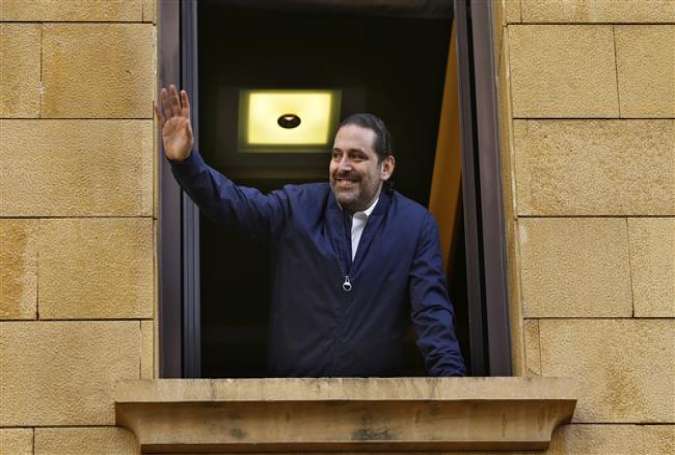 Lebanese Prime Minister Saad Hariri waves to his supporters from a window of his residence in Beirut, November 22, 2017, after returning from Saudi Arabia and putting his resignation on hold.