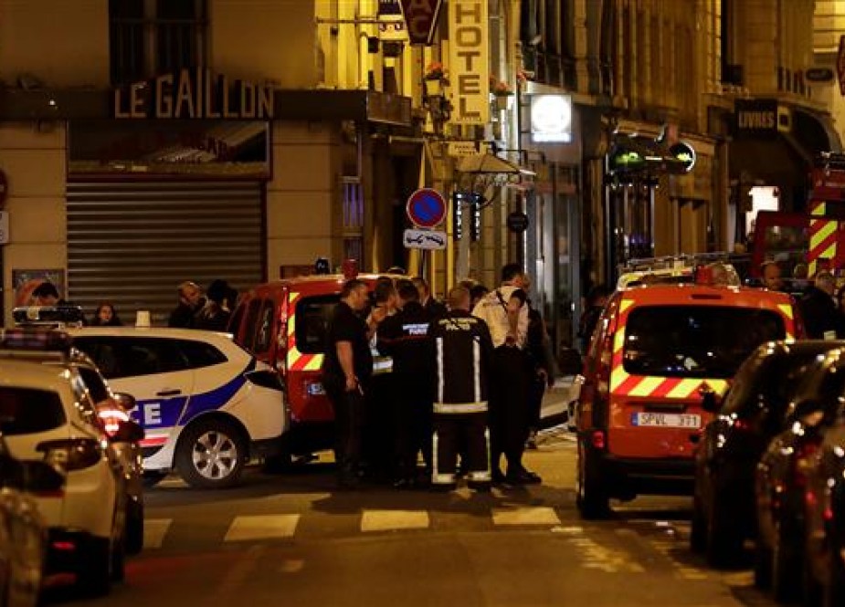 Policemen, firefighters and emergency service members stand in a blocked street in Paris centre after one person was killed and several injured by a man armed with a knife, who was shot dead by police in Paris on May 12, 2018. (Photo by AFP)