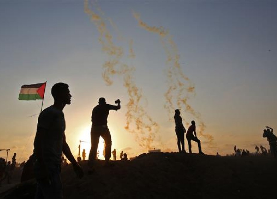 Palestinians protest as tear gas fumes erupt in the southern Gaza Strip on May 15, 2018. (Photo by AFP)