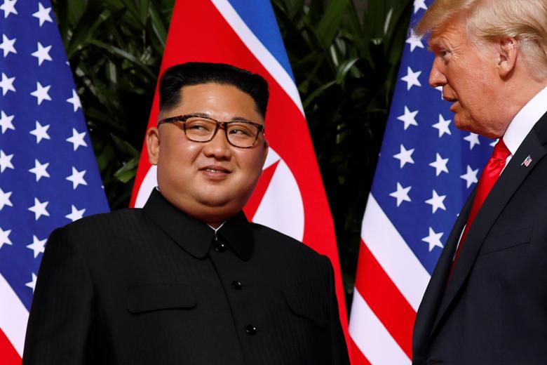 President Donald Trump and North Korean leader Kim Jong Un react at the Capella Hotel on Sentosa island in Singapore.