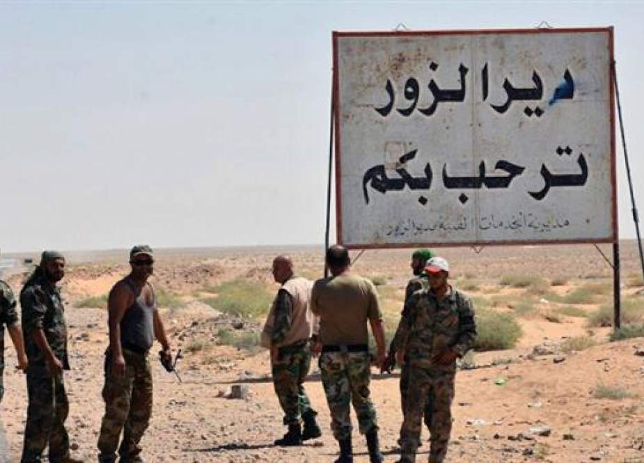 Syrian troops standing next to a sign in Arabic which reads, Day al-Zawr welcomes you..jpg