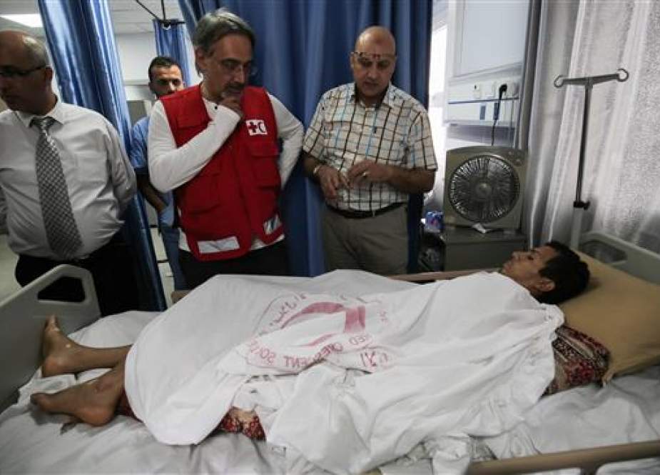 Francesco Rocca (2nd-L), the President of the International Federation of Red Cross and Red Crescent Societies, meets a Palestinian, receiving treatment for wounds sustained during protests at the Gaza border, during his tour of the Red Crescent Hospital in Khan Yunis in the southern Gaza Strip, on May 22, 2018. (Photo by AFP)