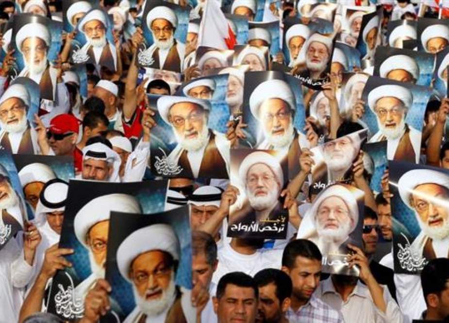 Anti-government protesters hold posters of Shia cleric Sheikh Isa Qassim in Budaiya, Bahrain, in 2013. (Photo by Reuters)