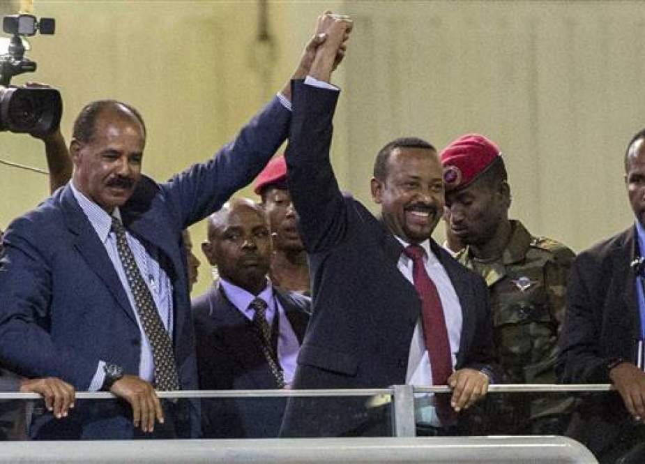 Eritrean President Isaias Afwerki (2nd-left) and Ethiopia’s Prime Minister Abiy Ahmed (C) hold hands as they wave at the crowds in Addis Ababa, Ethiopia, July 15, 2018. (Photo by AP)