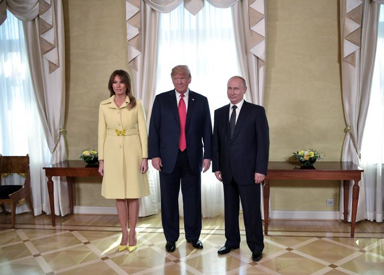Russia's President Vladimir Putin (R), President Donald Trump (C) and first lady Melania Trump attend a meeting.