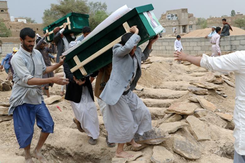 Mourners carry coffins during a funeral of people, mainly children, killed in a Saudi-led coalition air strike on a bus in northern Yemen, in Saada.