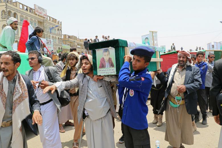 Mourners and a scout carry the coffin of a boy during the funeral of people killed in a Saudi-led coalition air strike on a bus in northern Yemen, in Saada.
