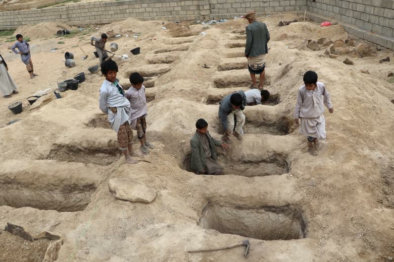 Boys inspect graves prepared for victims of Thursday's air strike in Saada province, Yemen August 10, 2018.