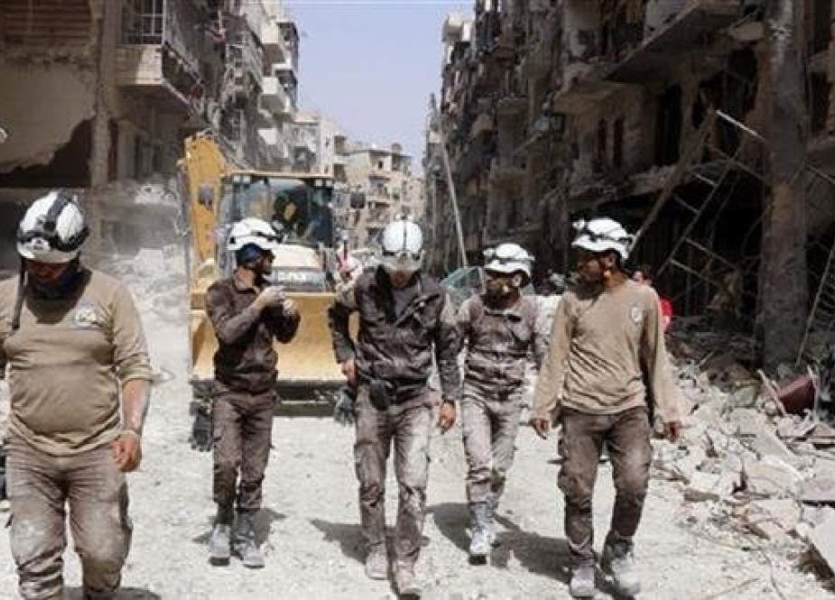 The undated photo shows members of the so-called White Helmets volunteer organization walking amid rubble in an undisclosed location in Syria.