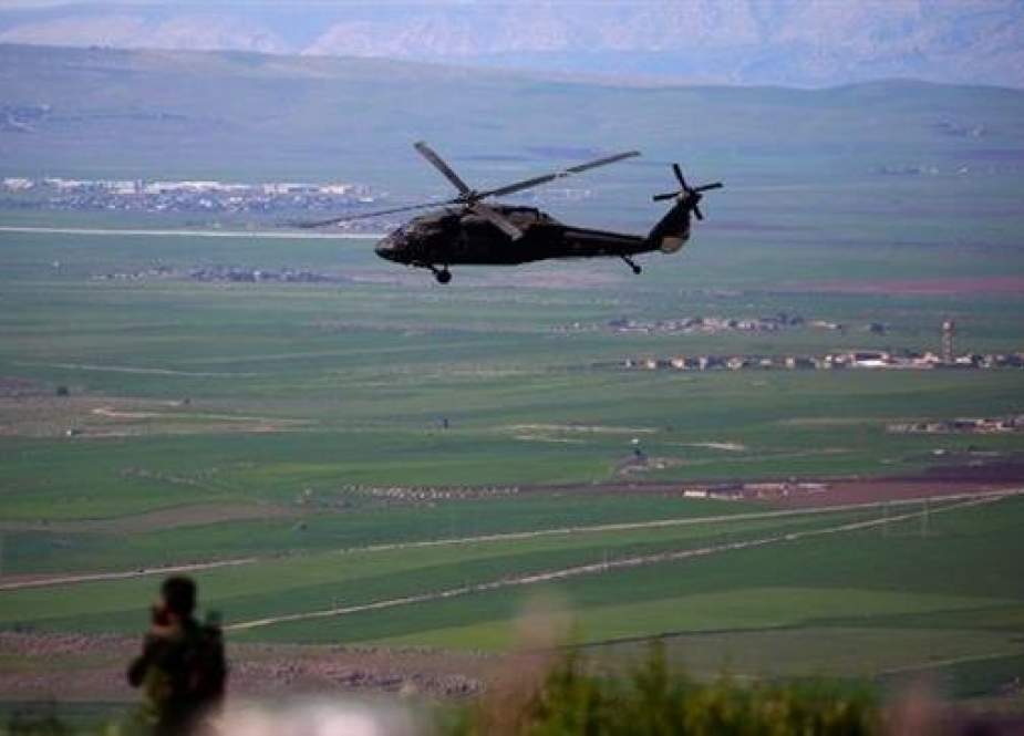 A helicopter, from the US-led coalition, flies over the site of Turkish airstrikes near northeastern Syrian Kurdish town of Derik, known as al-Malikiyah in Arabic, on April 25, 2017. (Photo by AFP)