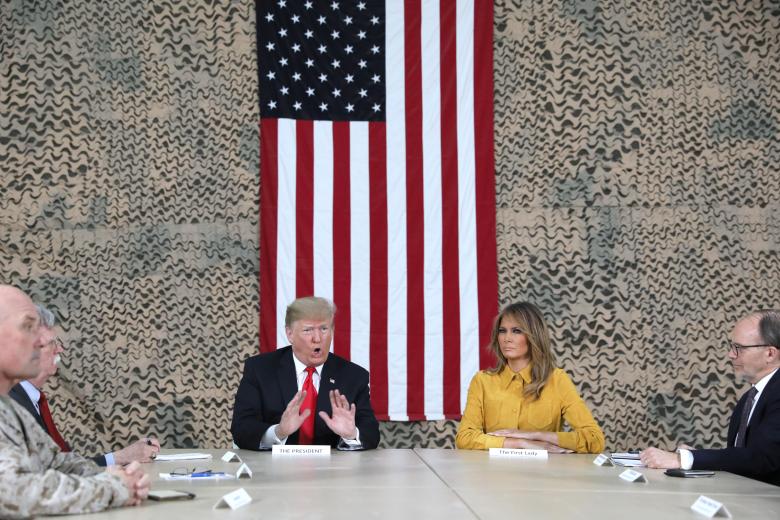 President Donald Trump, flanked by National Security Adviser John Bolton, first lady Melania Trump and U.S. Ambassador to Iraq Doug Silliman, meets political and military leaders during an unannounced visit to Al Asad Air Base, Iraq.