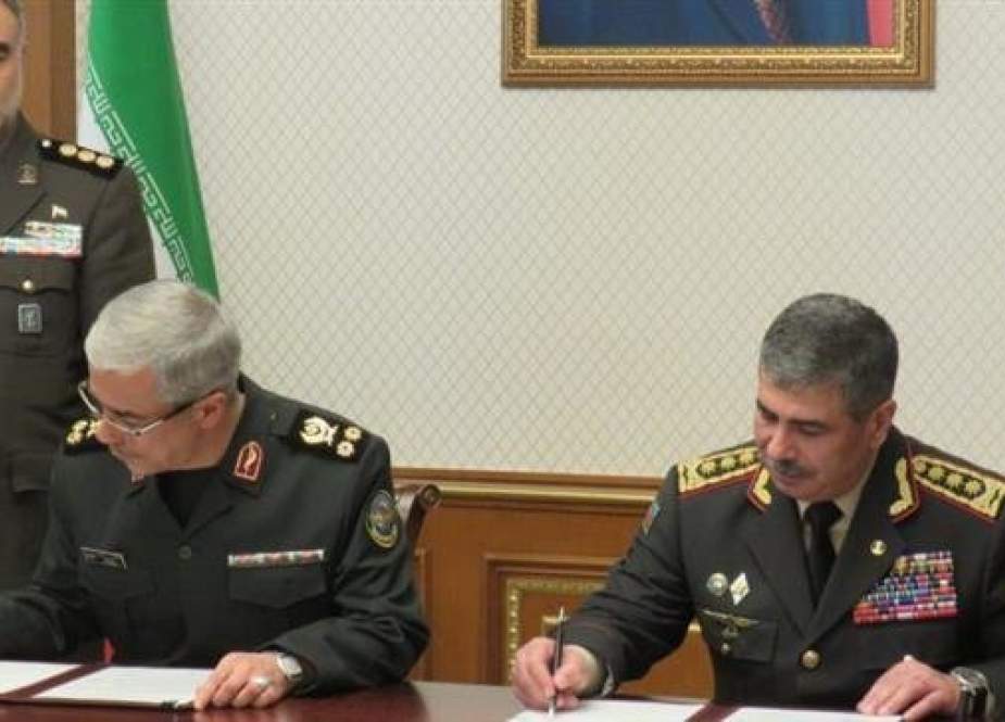 This photo taken from Azeri media shows Chairman of the Chiefs of Staff of the Iranian Armed Forces Major General Mohammad Baqeri (L) and Azerbaijan’s Defense Minister Lieutenant General Zakir Hasanov signing a memorandum of understanding to boost bilateral defense and military cooperation in Azeri capital on January 16, 2019.