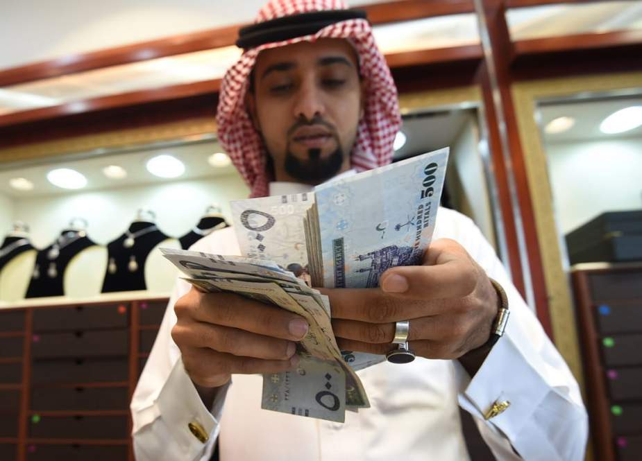 A man counts Saudi riyal banknotes at his jewelry shop in Tiba market in the capital, Riyadh, October 3, 2016. (Photo by AFP)