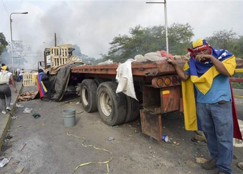 Demonstrators throw stones after a truck with humanitarian aid was set on fire at the Francisco de Paula Santander international bridge Bridge linking Cucuta, Colombia, and Urena, Venezuela, during an attempt to cross over the border into Venezuela, on February 23, 2019. (AFP)