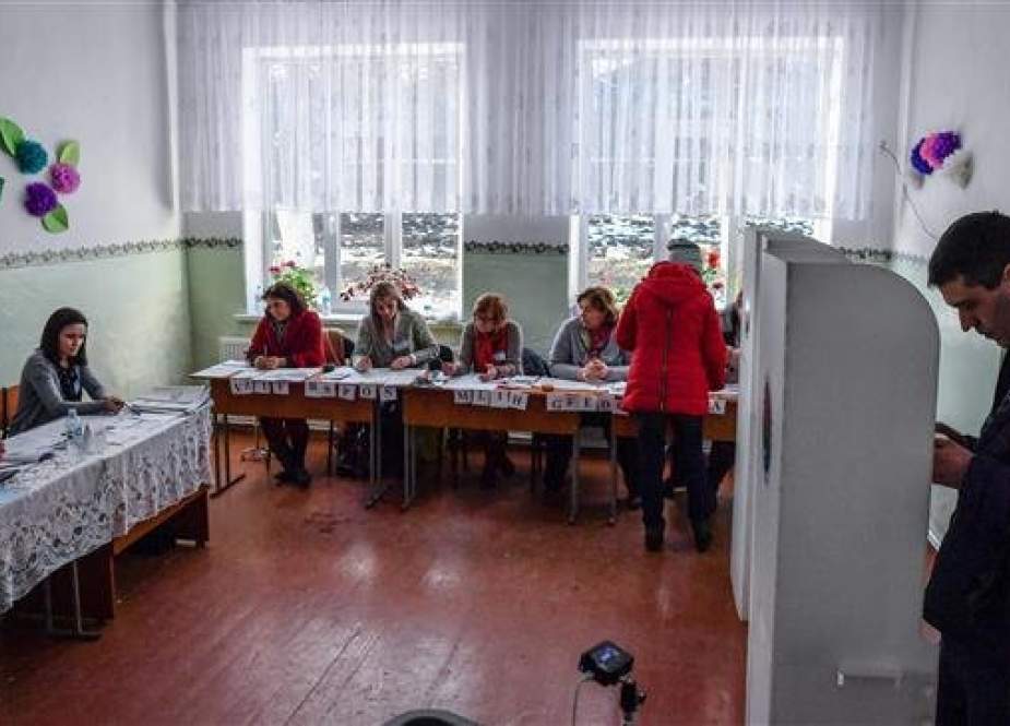 A man prepares his vote in a polling booth at a polling station in Pojareni village, on February 24, 2019, as Moldovans are called to the polls to elect new parliament members. (Photo by AFP)