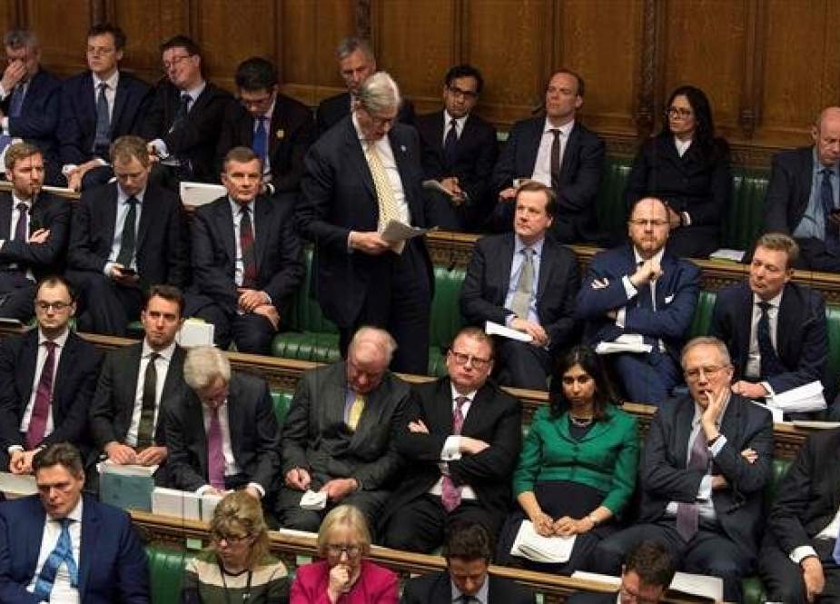 A handout photograph released by the UK Parliament shows Members of Parliament listening in the House of Commons in London on March 12, 2019. (AFP photo)