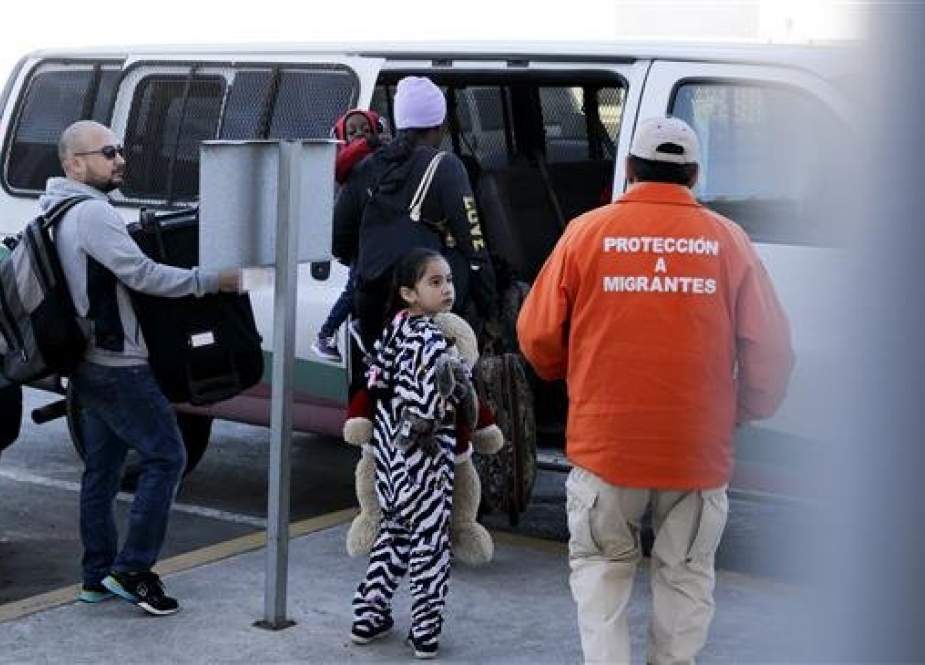 A family boards a bus on their way to apply for asylum in the United States, at the border in Tijuana, Mexico, on January 25, 2019. (Photo by AP)
