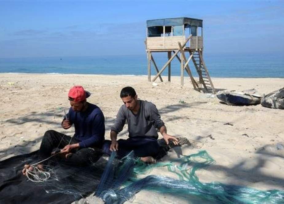 Palestinian fishermen mend a fishing net as they sit along the sandy beach at Khan Younis in the southern Gaza Strip, March 10, 2019. (Photo by AFP)
