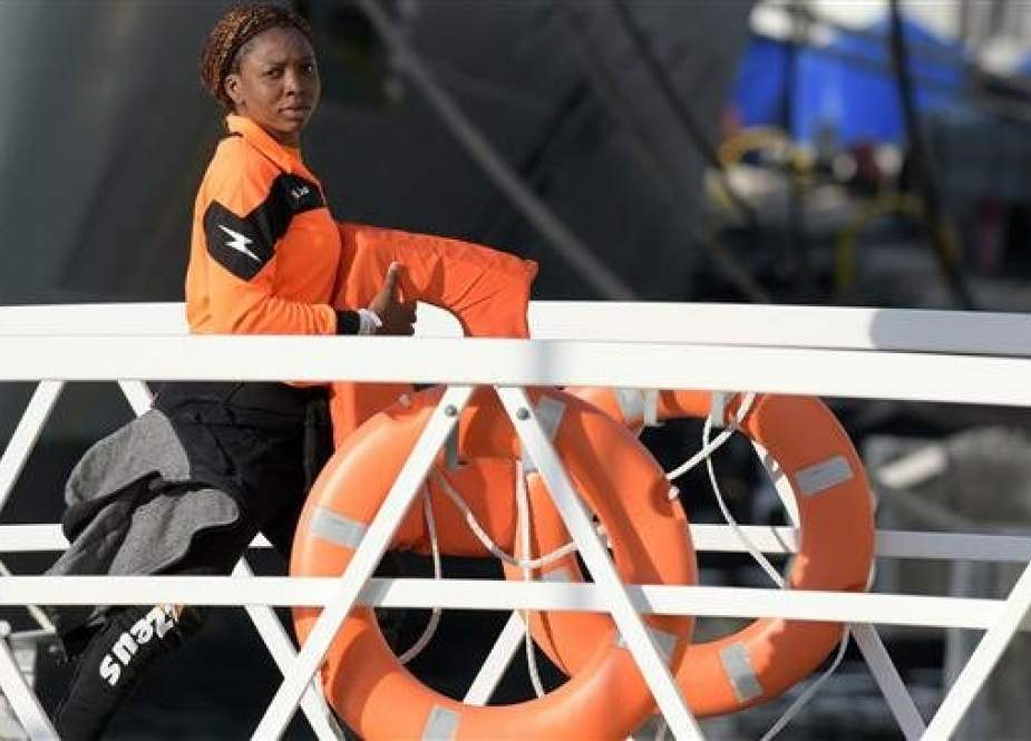 A woman, with the migrants who were stuck on a ship since their rescue in the Mediterranean 10 days ago, disembarks in Valletta, Malta, on April 13, 2019 after four European countries agreed to take the migrants in. (Photo by AFP)