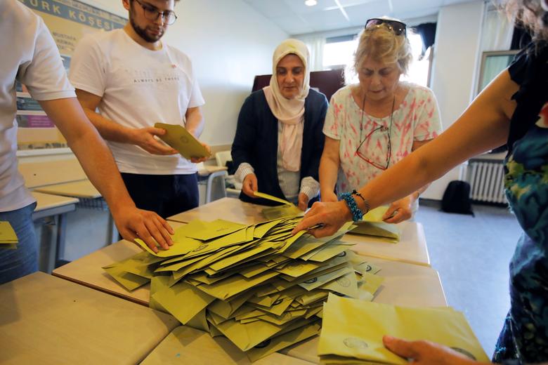 Election officials open a ballot box to count votes at a polling station in Istanbul, June 23