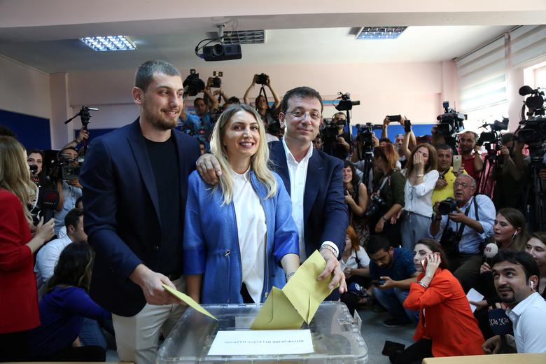 Ekrem Imamoglu, mayoral candidate of the main opposition Republican People's Party (CHP), his wife Dilek and their son Semih cast their ballots at a polling station in Istanbul, June 23