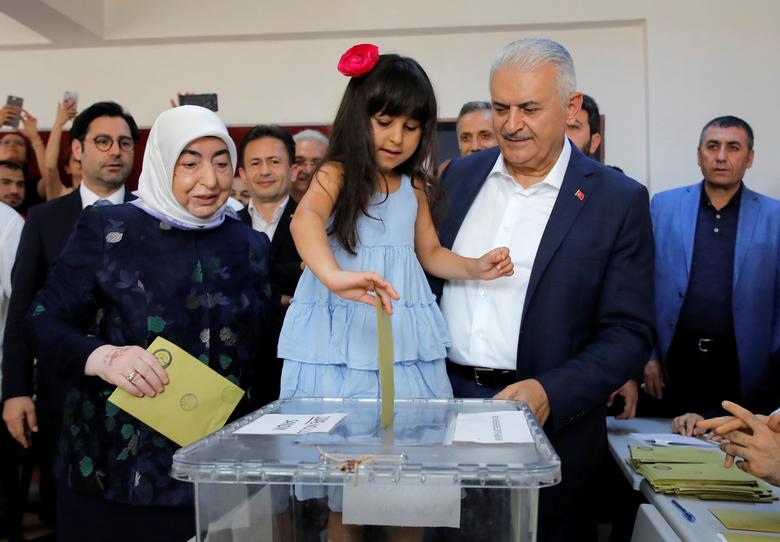 Binali Yildirim, mayoral candidate of the ruling AK Party, poses with his wife Semiha and granddaughter casting a ballot at a polling station in Istanbul, June 23
