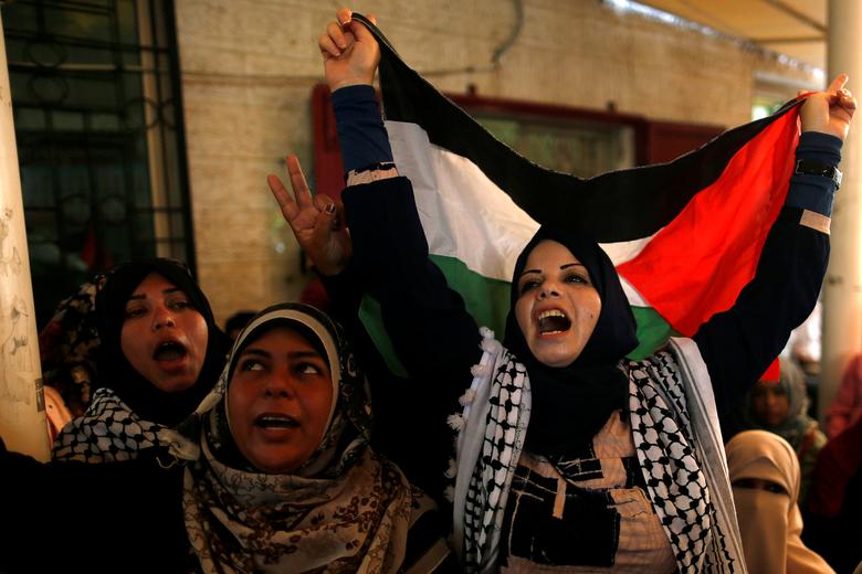Palestinian woman take part in a protest against Bahrain's workshop for U.S. peace plan, in Gaza City, June 24